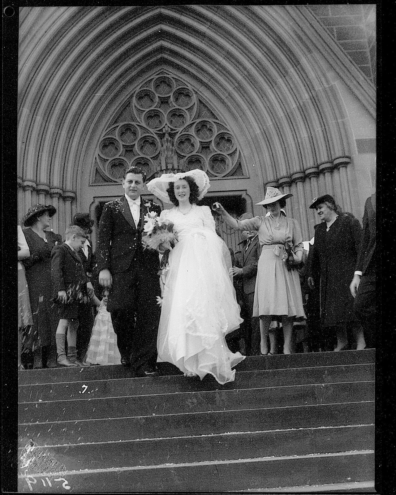 Archival photograph of a bride and groom walking down cathedral steps